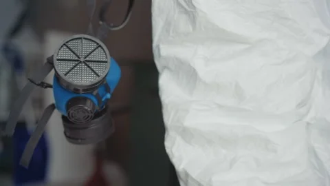 Technician examining protective mask carefully. Focused examination of Stock Footage 346470584