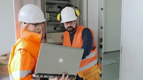 Technician fixes switchboard while woman controls process Stock Footage 144098460