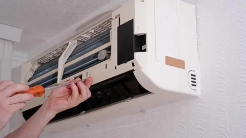Technician fixing air conditioner unit with screwdriver Stock Footage 338008560