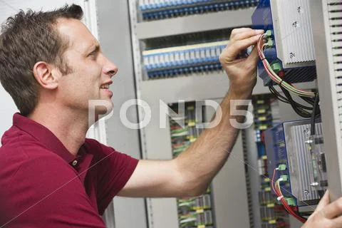 Technician Fixing Cable Wires Of Circuit Board