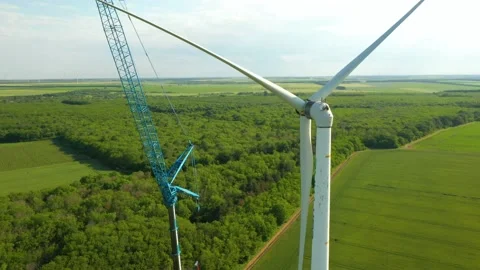 Technician fixing turbine blade with maintenance crane in wind farm Stock Footage 176723591