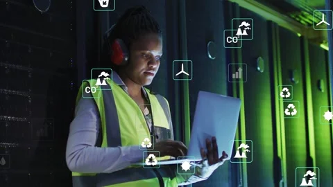 Technician glancing, typing on laptop at server racks, animated energy icons Stock Footage 332746983
