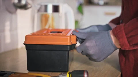 A technician in gloves and work uniform carefully places a toolbox on a kitc Stock Footage 342240040