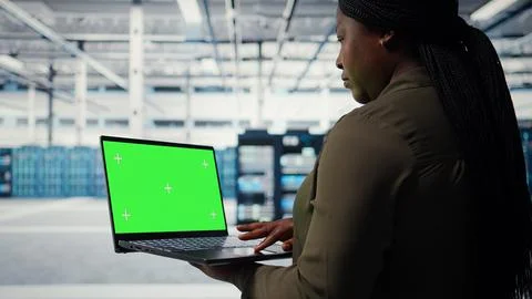 Technician with green screen laptop in data center Stockfoto's