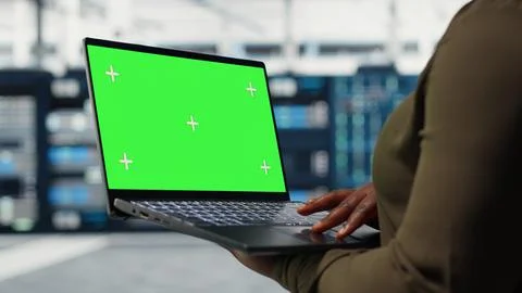 Technician with green screen laptop in data center Stock Photos
