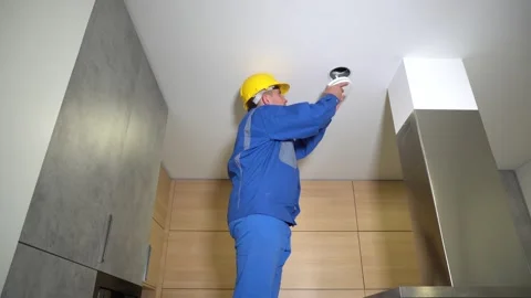 Technician guy install new air diffuser into private house kitchen ceiling Video stock 131176600