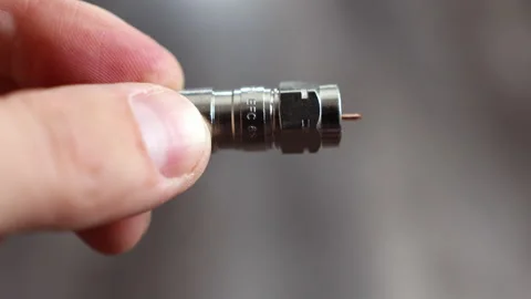 Technician handling a coaxial copper cable, trimming the inner copper core Stockbeeldmateriaal 312358414