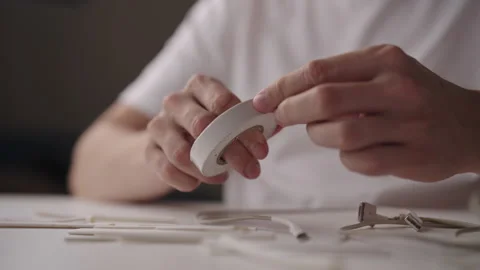 Technician hands applying insulating tape to damaged charging cable, surrounded Stock Footage 317308541