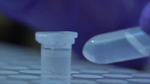 Technician hands mark small plastic test tube of clear liquid Stock Footage 327046768