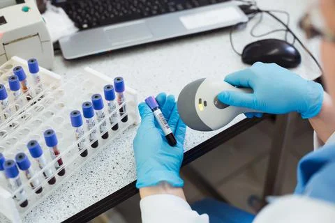 Technician hands scanning bar codes on biological sample tube in the lab of Stock Photos