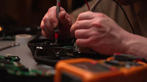 Technician hands using multimeter to check circuits of fpv drone, surrounded by Stock Footage 305507793