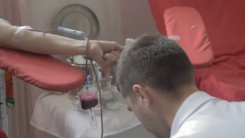 Technician helps during donor pumps hand, giving blood  by Pakito. Stock Footage 74167927