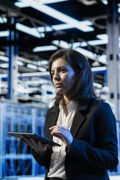 Technician in high tech data center using tablet, managing server virtualization Foto stock