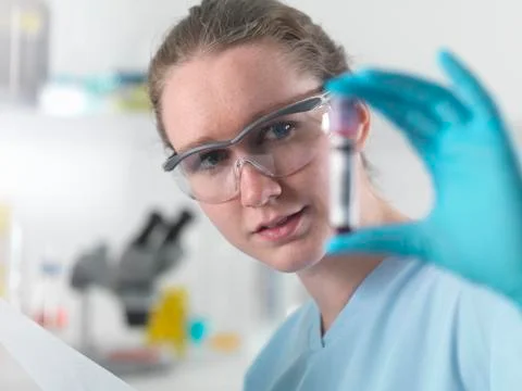 Technician holding bar coded blood sample in clinical laboratory Stock-Fotos
