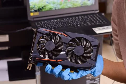 The technician is holding a computer graphics card and other computer compo.. Stock Photos