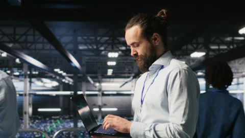 Technician holding laptop walking on server farm platform Stock Footage 310275947