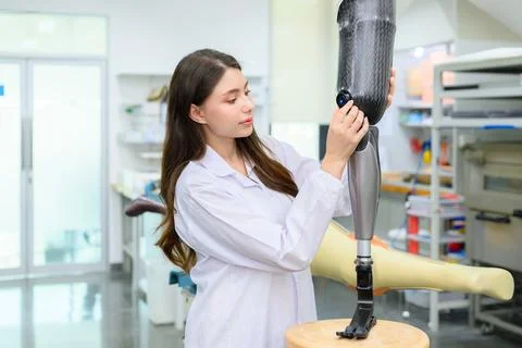 Technician holding prosthetic limb checking and working in laboratory Stock Photos