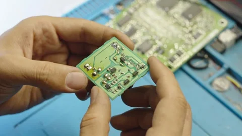 Technician holding small electronic circuit board in his hands at workspace. Stock Footage 340274406