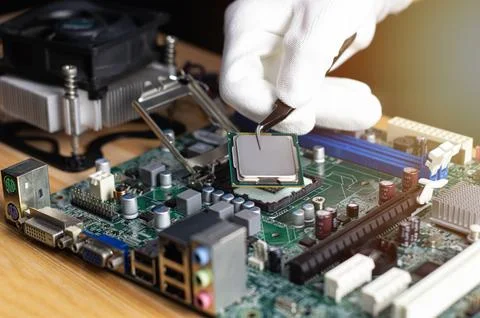 Technician inserting CPU into computer motherboard, computer repair technicia 库存照片