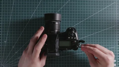 Technician inserting SD memory card into mirrorless digital camera Stock Footage 333763916