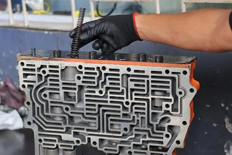 Technician Inserting Spring into Automatic Transmission Control Valve Body. Stock Photos