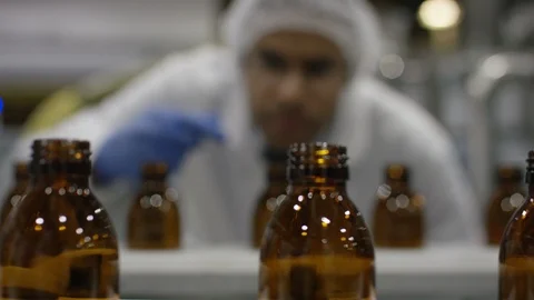 Technician inspected empty bottles on production line in cosmetic factory Stock Footage 107985388