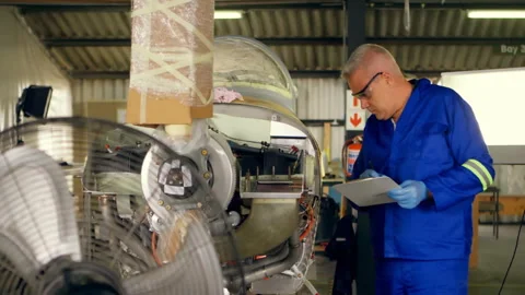 Technician inspecting aircraft engine in hangar while animated data graphs and Stock Footage 309097808