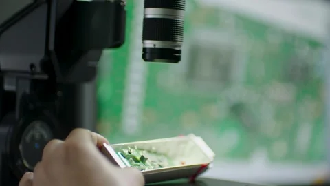 Technician Inspecting Circuit Board Under Microscope in Electronics Laboratory Stock Footage 334432419