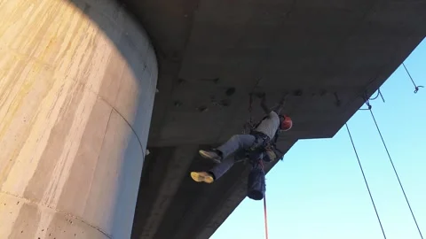 Technician inspecting concrete bridge underside Stock Footage 307312121