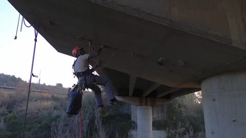 Technician inspecting concrete bridge underside Stock Footage 307312138