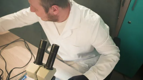 Technician Inspecting Electronics Through Microscope in Lab Video stock 282649510