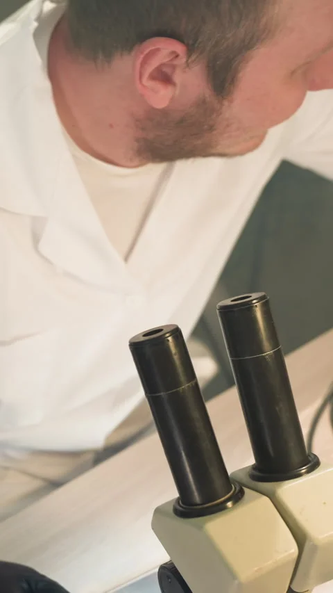 Technician Inspecting Electronics Through Microscope in Lab Video stock 310490675