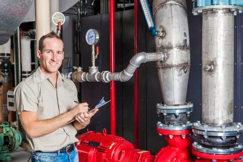 Technician inspecting heating system in boiler room Foto stock