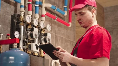 Technician Inspecting Heating System With Digital Tablet Stock Footage 330858624