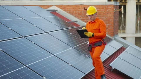 Technician inspecting solar panels on rooftop Stock Footage 343894793