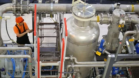 Technician inspects complex gas processing equipment at industrial facility Stock Footage 282845485