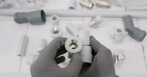 Technician inspects tee fitting and verifies female thread Stockbeeldmateriaal 322008206