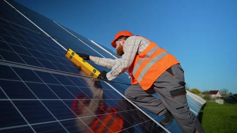 Technician installing and checking solar panels with spirit level Stock Footage 314405060