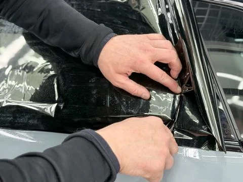 Technician Installing car window tint. Window toned film. Car window tintin.. Stock Photos
