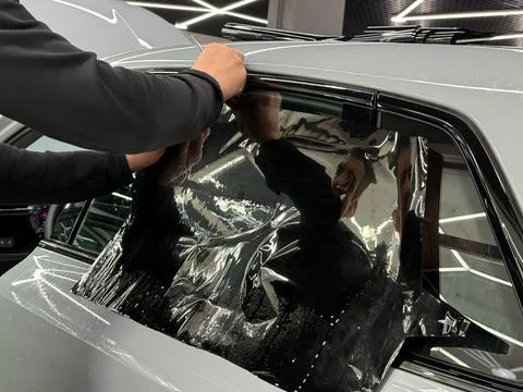 Technician Installing car window tint. Window toned film. Car window tintin.. Stock Photos