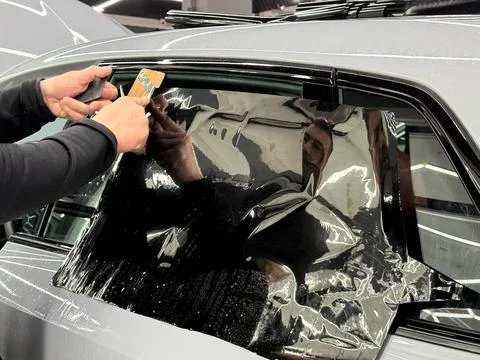 Technician Installing car window tint. Window toned film. Car window tintin.. Stock Photos