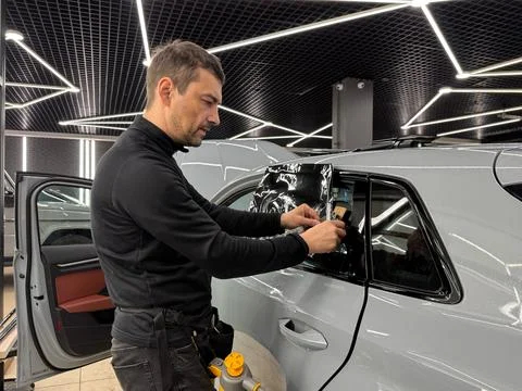 Technician Installing car window tint. Window toned film. Car window tintin.. Stock Photos
