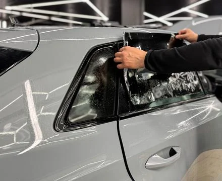 Technician Installing car window tint. Window toned film. Car window tintin.. Stock Photos