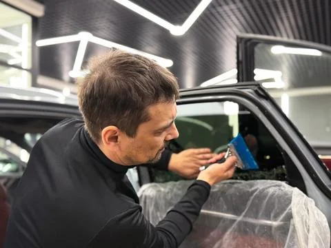 Technician Installing car window tint. Window toned film. Car window tintin.. Stock Photos