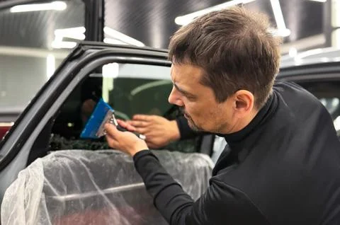 Technician Installing car window tint. Window toned film. Car window tintin.. Stock Photos