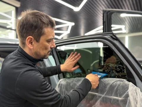 Technician Installing car window tint. Window toned film. Car window tintin.. Stock Photos
