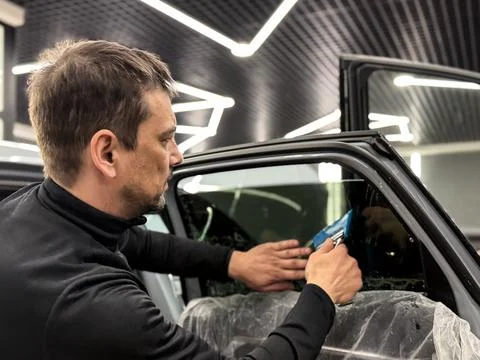 Technician Installing car window tint. Window toned film. Car window tintin.. Stock Photos