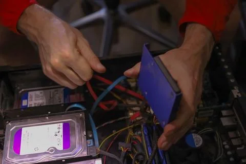 Technician installing hard drive into computer case Stock Photos