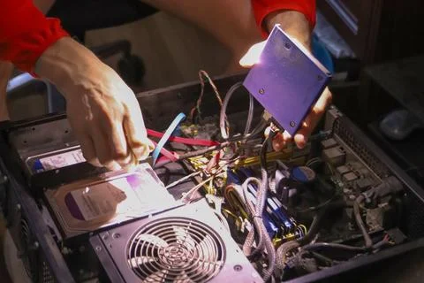 Technician installing hard drive into open computer tower Stock Photos
