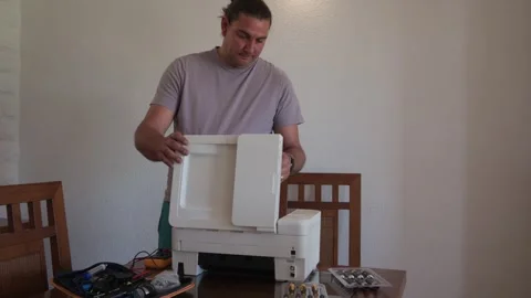 Technician installing ink cartridges into a new multifunction printer at home Stock Footage 336950809